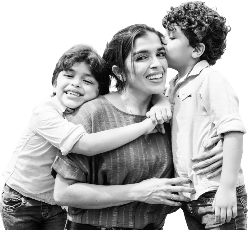 A laughing mother hugged by her two young sons