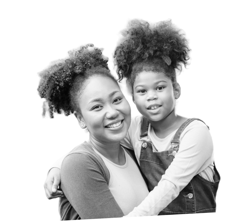 A mother holding her young daughter, both smiling